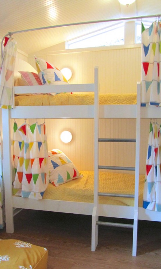 a large white bunk bed unit with a ladder, wall lamps and colorful bedding with various prints