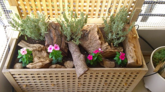 an IKEA Hol table placed on a balcony for decor and filled with wood, greenery and blooms for a natural look