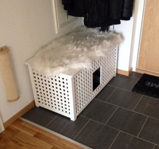a white IKEA Hol table as a cabinet in the entryway and a cat toilet at the same time is a space-saving idea