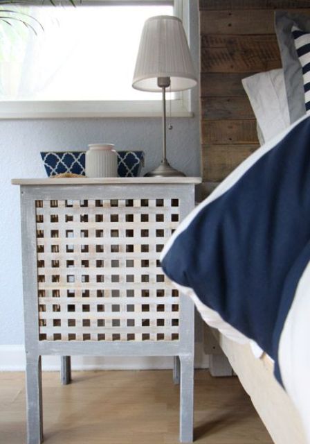 a whitewashed Hol table by IKEA used as a simple nightstand with a lot of storage space inside