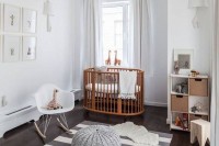 a stylish grey and white nursery with neutral furniture, a wooden crib, some simple textiles and a gallery wall is very welcoming