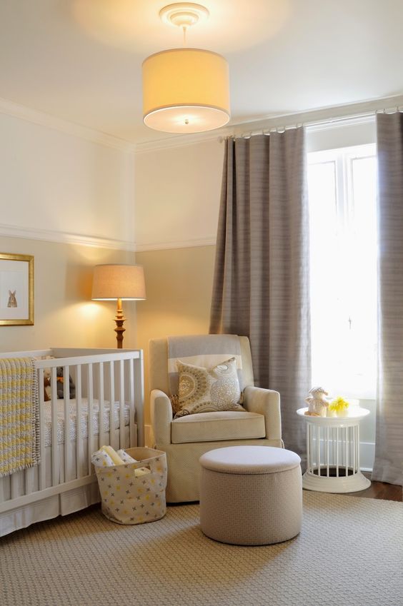 a welcoming and cozy neutral nursery with color block walls, touches of tan, yellow and taupe curtains, lamps that match