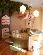 a fairy-tale girl’s room with a tree with pink doors, a round kid bed with pink bedding, whimsical flower-shaped lamps and some rugs