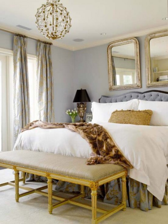 a refined glam bedroom with grey walls, chic mirrors, a globe chandelier, a printed bench and curtains on the windows