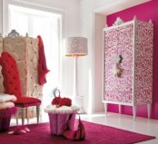 a pink, red and white glam bedroom with a printed wardrobe, a refined screen, a red chair and a pink rug on the floor