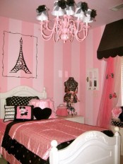 a pink, black and white glam bedroom themed as Paris, with creative textiles and a chic chandelier with shades