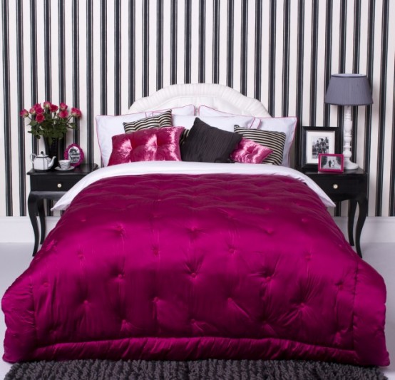 a black and white glam bedroom with a striped statement wall, black furniture and a fuchsia duvet for a touch of color