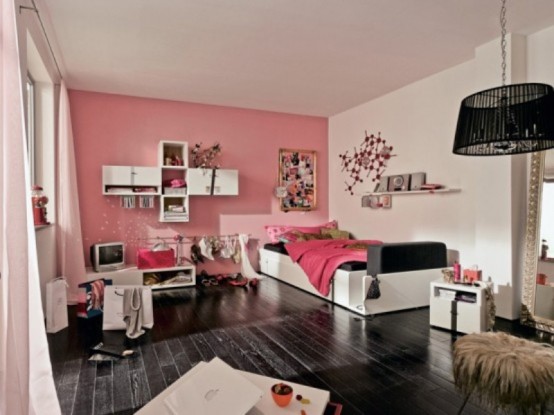 a girlish pink, black and white bedroom with a statement wall, touches of black ro drama and catchy art