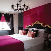 a glam fuchsia and black bedroom with a refined bed, a black chandelier and touches of gold for a bright look