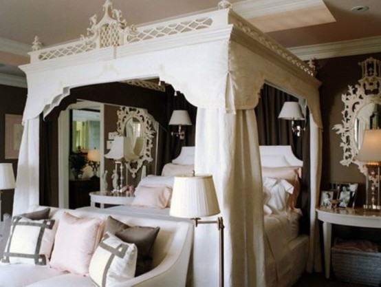 a refined black and white bedroom with a fantastic white carved bed with curtains, ornate mirrors and a chic sofa with pillows