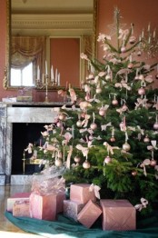 a large Christmas tree decorated with pastel pink ornaments and bows plus pastel pink gift boxes under the tree