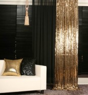 a gold sequin curtain and a gold sequin pillow in a black and white space create a cool glam feel