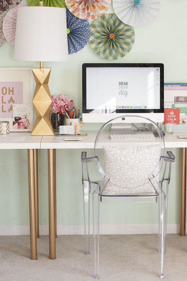 a white desk with gilded legs, a sculptural faceted table lamp give a slight glam like feel to the home office