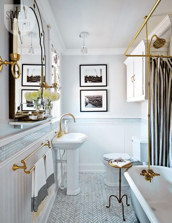 a refined retro bathroom in neutrals, with a black and white gallery wlal, a striped curtain, a refined mirror and gold fixtures and other touches for a glam feel