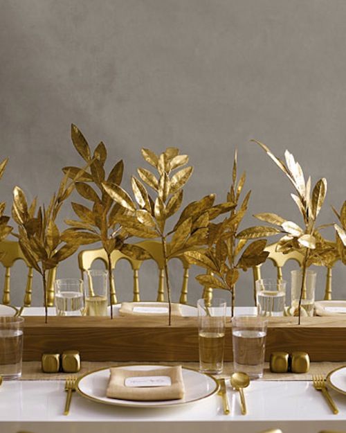 a wooden slab with gilded leaves, gold cutlery and gold touches for a chic and refined Thanksgiving tablescape