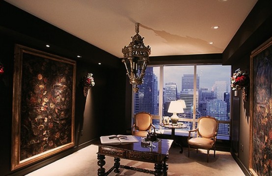 a refined and moody home office with a Gothic feel, with black walls, statement floral artworks, a heavy carved desk, chic chairs and a bold pendant lamp over the desk