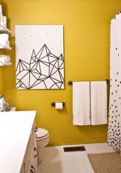 a mustard and white bathroom with neutral textiles, a bold black and white artwork and white appliances