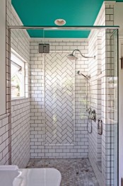 a white subway tile shower space with a herringbone accent and a turquoise ceiling is a bold and cool idea