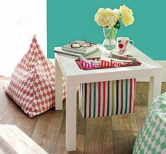 an IKEA Lack table with a built-in striped sack for storing newspapers is a gorgeous idea for a modern living room, and a fun touch of color