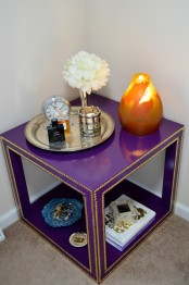 a couple of Lack tables made over into a unique and colorful coffee table with a lower shelf, done in bold purple and with decorative nails – such an IKEA hack just wows