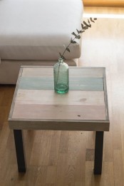 an IKEA Lack table with black legs and a striped tabletop is a lovely addition to a stylish and relaxed living room, with a touch of blue or aqua