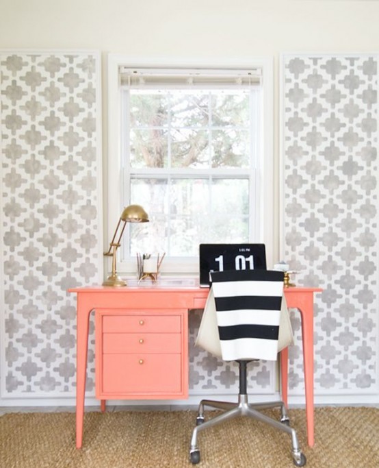 a bright home office nook with grey printed wallpaper, a coral desk, gold touches and a striped chair