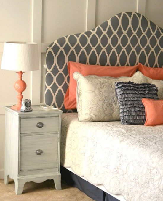 a grey, creamy and coral bedroom with print touches, a whietwashed nightstand, a vintage lamp with a coral base