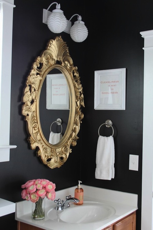 a moody guest toilet done in black and white, with a copper vanity and a mirror in a refined gold mirror frame a moody guest toilet done in black and white, with a copper vanity and a mirror in a refined gold mirror frame