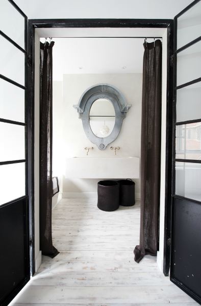 an eclectic guest toilet done in neutrals, a large wall mounted sink and a mirror in a patina frame an eclectic guest toilet done in neutrals, a large wall-mounted sink and a mirror in a patina frame