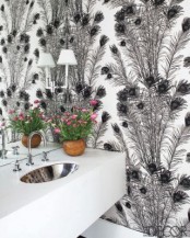 a monochromatic guest toilet with printed wallpaper, a white wall-mounted vanity and a lamp