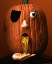 a scary pumpkin with an eye and nose used to serve candies is a creative idea for Halloween party decor
