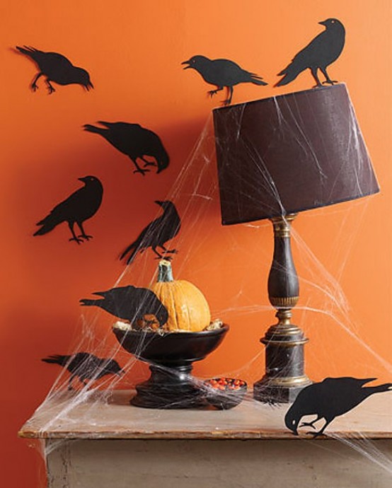 a black table lamp, a black bowl with a pumpkin and spider web, blackbirds all around for lovely Halloween decor