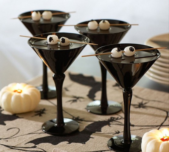 black glasses with black drinks and white drink stirrers that imitate googly eyes are perfect for Halloween