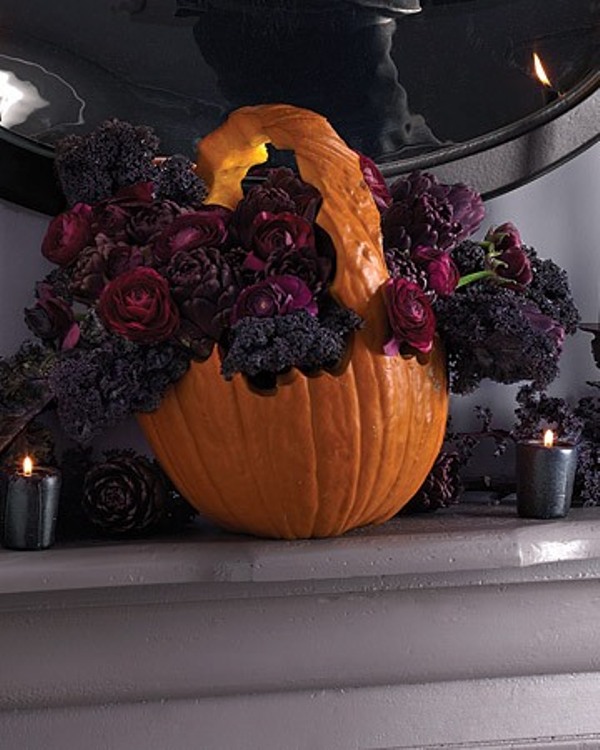 a basket cut out of an orange pumpkin and filled with deep purple and black flowers is a lovely idea for Halloween, it will be a nice decoration