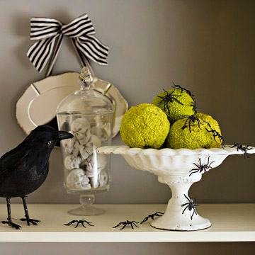 Place a few hedge apples on a small cake stand and a bunch of faux spiders all around. A crow could watch them dance!