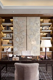 a large bookcase with lights and refined fabric panels hiding the TV are a great idea for a sophisticated home office