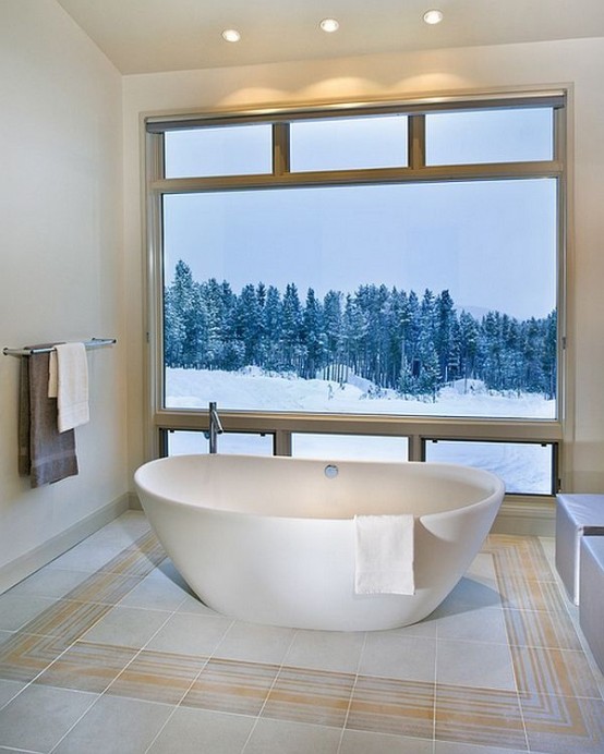 a neutral home space with a glazed wall to enjoy the views and a tub placed in front of the window and lights is a great space to relax