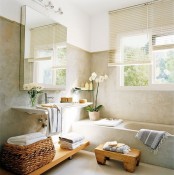 a welcoming neutral home space with a built-in bathtub, a floating sink, a mirror cabinet, woodne shelves and a small stool