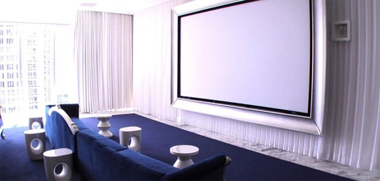 a stylish home theater with a large screen, a glazed wall that can be hidden with curtains and a navy floor and matching navy furniture