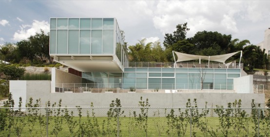 House Composed By Two Rectangular Prisms On A Sloped Site