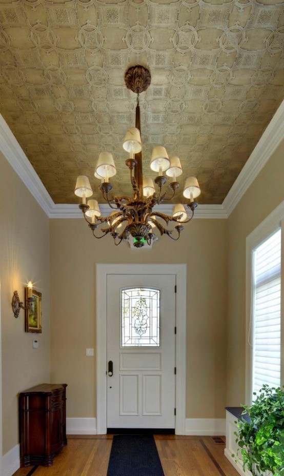 a lovely gold vintage-inspired ceiling done with wallpaper and with a large and heavy vintage-inspired chandelier