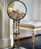 a round vintage fish tank filled with various seashells and starfish will remind you of the sea and seashores