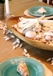 a large wooden bread bowl with seashells and starfish is a perfect and easy centerpiece both for indoors and outdoors