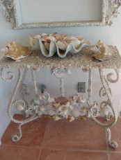 a vintage and elegant console table with seashells – decorated with them and with seashells on it for a coastal feel