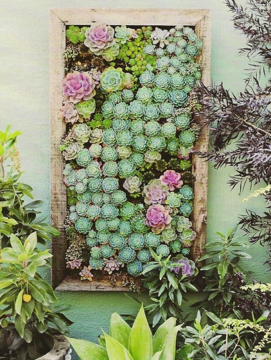 a large vertical planter with succulents and flowers is a veyr bold and chic solution to go for