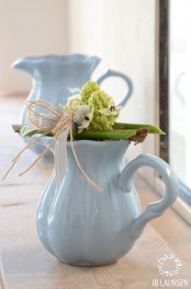vintage blue teapots and milkpots with greenery and neutral blooms will give a slight vintage or rustic feel to the space