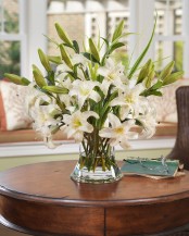 a clear vase with lots of white lilies is an elegant and chic decoration or centerpiece for any party