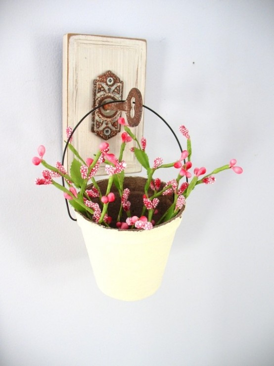a white bucket with pink blooms hanging on a vintage key is a lovely decoration for both indoors and outdoors