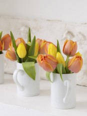 white teacups with colorful tulips are nice spring decorations with plenty of contrast