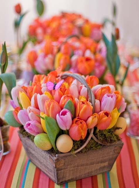 a wooden box with moss, colorful tulips and fake eggs is a nice Easter decoration with a bright look